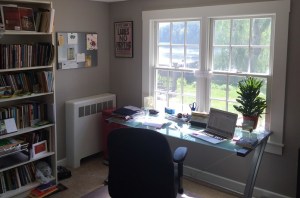 Kirun's desk and bookshelf in front of a large window