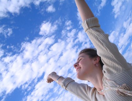 Rejoicing woman with arms reaching towards sky